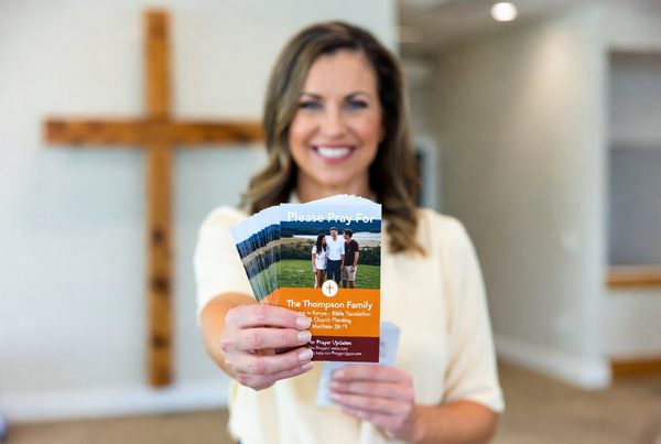 Woman holding a stack of missionary prayer cards
